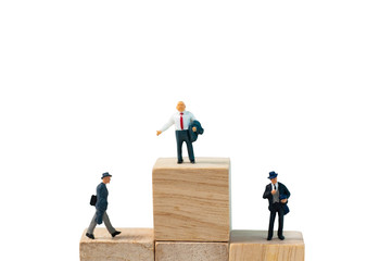 Clipping path, Selective focus miniature business people action on wooden block.  Happy successful leader or manager business man standing on top of business partnership with copy space isolated .