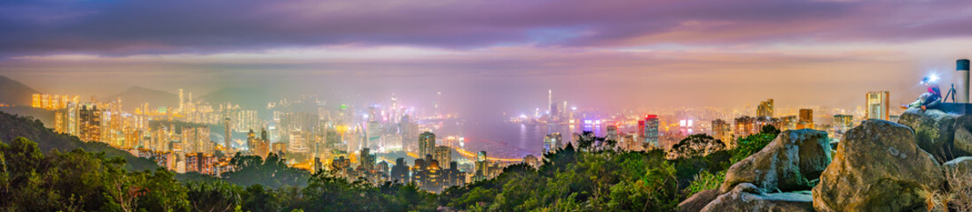 Obraz premium Hong Kong night panorama wide view of Victoria Harbour skyline from Red incense burner summit,Misty night.