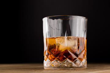 Whiskey with Ice on Wooden Table and black background.Real Ice. Copy Space