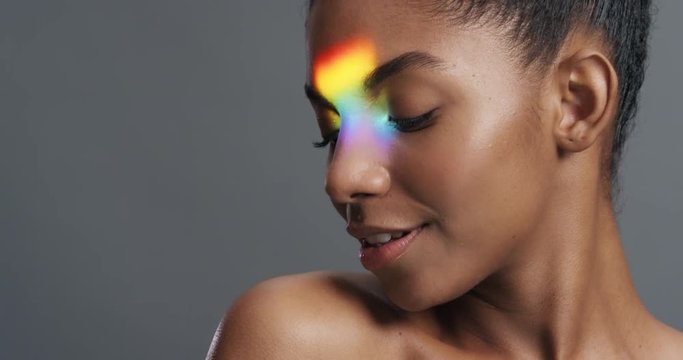 multicolor portrait beautiful african american woman with colorful light reflecting on bare skin looking healthy complexion skincare concept