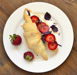 Croissant with cream cheese, strawberries and basil for breakfast, top view 