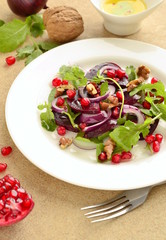 Beetroot salad with arugula, walnuts and pomegranate seeds, vertical 