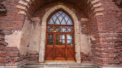 Fototapeta na wymiar Brown and red brick wall textured background and wooden door and arch