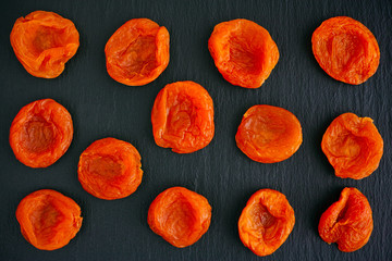 Dried apricots on black background.
