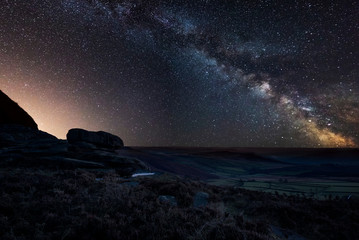 Vibrant Milky Way composite image over landscape of Peak District National Park in England