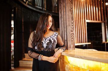 Pretty indian girl in black saree dress posed at restaurant.