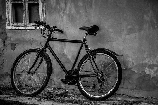 Black bicycle parking at the old house in black and white.