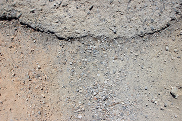Dirt road ending asphalt border close up texture