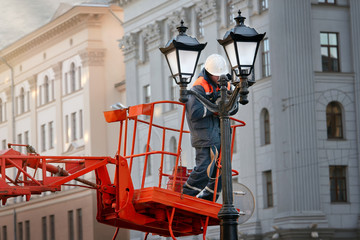 Worker during work on replacement of old ceiling light cover with new ones. Professional service...