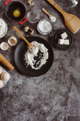 Ingredients and utensils for baking. Spoon with flour, dishes, eggs,  butter salt and rolling pin on a grey background. Flat lay. Text space