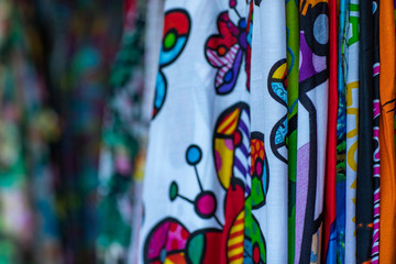 Colorful fabrics hanging and lined. Fabrics with different patterns and colored rows. Wide selection of different color textile. 