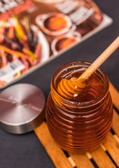 Honey jar with a wooden drizzler and with copyspace