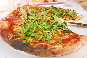 Pizza with mozzarella, tomato and arugula