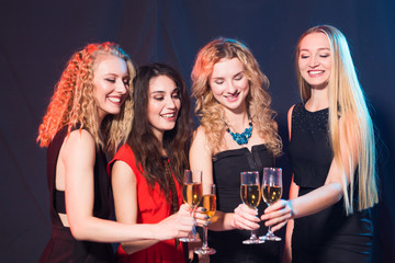 Party, holidays, celebration and nightlife concept - smiling female friends with glasses of champagne in club