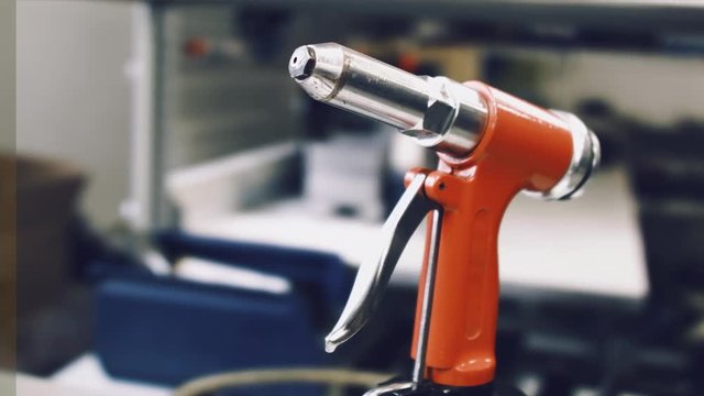 Pop rivet gun for metal. New rivet gun on natural background in workshop.