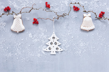 Christmas holiday background with red berries, gingerbread and Christmas decoration on light grey background with snow. Top view, close up, Christmas and New Year concept. Bio and ecological materials