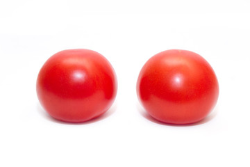 Two juicy red tomatoes isolated on white background. Side view