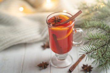 Mulled wine in a transparent mug on a light background. Conception of heat, cold winter, warming, spices
