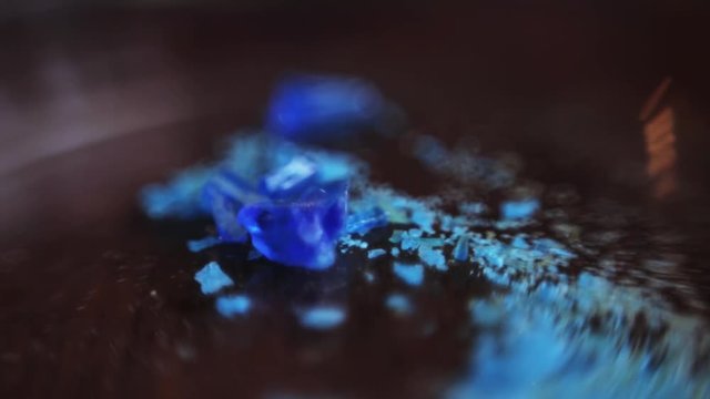 Blue samples of precious metals. Particles of minerals lying on table of laboratory. Research center. Chemistry. Nature. Indoors.