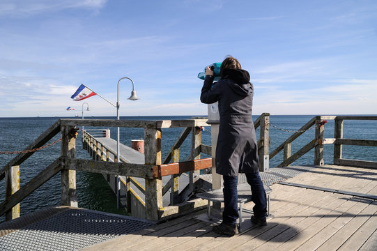 Europa, Deutschland, Mecklenburg-Vorpommern, Landkreis Vorpommern-R&uuml;gen, G&ouml;hren, Person schaut durch ein Fernglas auf der Seebr&uuml;cke