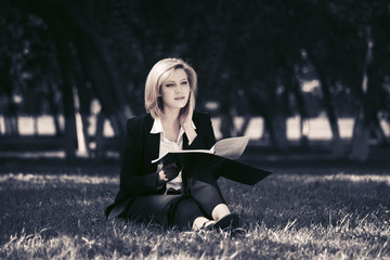 Young business woman with file folder in city park