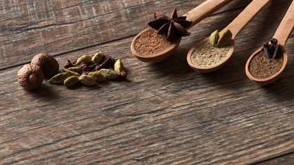 Cardamom, cloves, nutmeg, star anise, allspice. Different types of whole Indian spices in wooden background close-up. Healthy food.