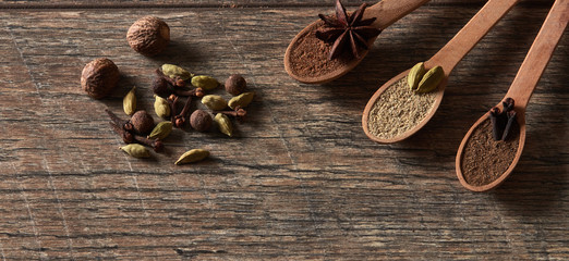 Cardamom, cloves, nutmeg, star anise, allspice. Different types of whole Indian spices in wooden background close-up. Healthy food.