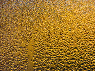 Drops of water on a cold glass.