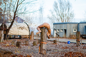 Kaputte Figur auf Holzpfahl 