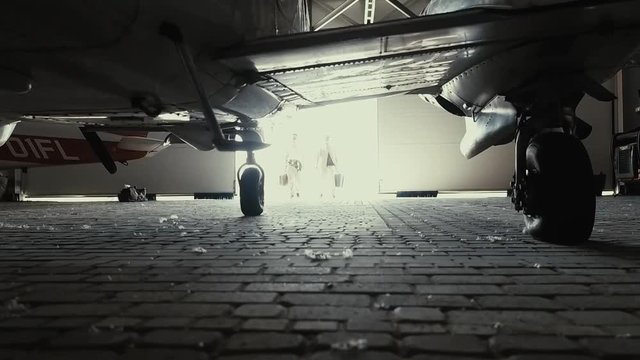 Detailed shooting of a small passenger plane in the hangar, close-up details, panorama of the surf, hands hold the steering wheel, dashboard, steel propeller, chassis, gauges