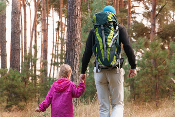 Father hiking with kid on backpack