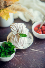 Fresh homemade marshmallow with raspberry and mint on dark background.