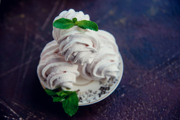 Fresh homemade marshmallow with raspberry and mint on dark background.