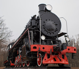 Old black steam locomotive with red decoration, front view
