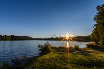 A radiant sunset with a sun star at a Scandinavian lake!