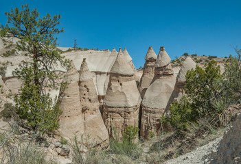 Towering hoodoos with rock caps march forward from a cliff 