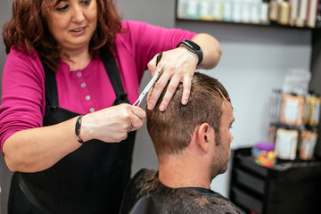 Obraz na płótnie Canvas Man having his hair cut in a barbershop