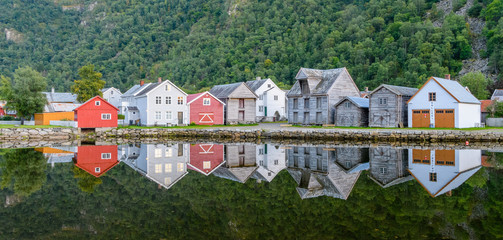The old town of Gamla L&aelig;rdals&oslash;yri is reflected in a calm and clear lake - a typical village in Norway.