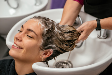 Obraz na płótnie Canvas Woman having her hair washed in a salon