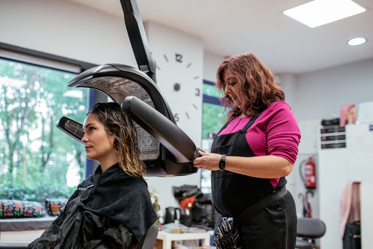 Woman In A Professional Hairdresser Infrared Hair Dryer