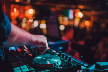 DJ remote, turntables, and hands . Night life at the club, party.