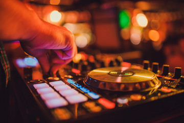 DJ remote, turntables, and hands . Night life at the club, party.