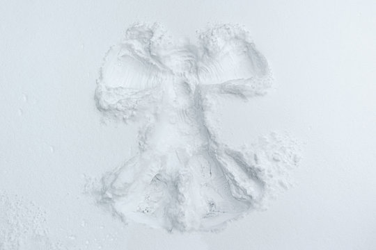 A beautiful snow angel made by a child on snow-white snow.