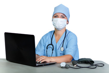 Woman doctor with a stethoscope in a medical mask at the table at the computer on a white background.