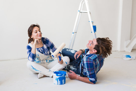 People, repair and relationship concept - Young funny couple doing renovation in new apartment