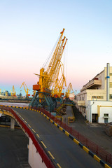 Fototapeta na wymiar Cargo port with cranes for lifting containers at sunset
