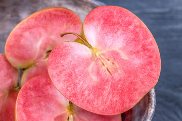 Pink and red fleshed apples on a dark background. Apples with pink flesh
