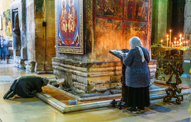 Woman praying in Svetitskhoveli Cathedral in Mtskheta, Georgia