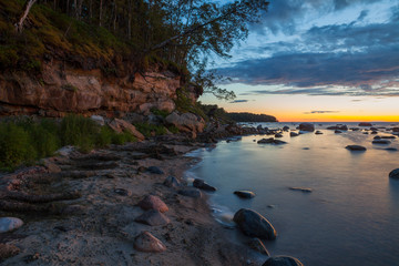 Late sunset over the limestone cliff along the sea. Estonia.