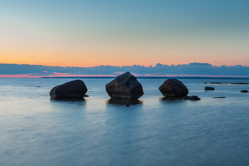 Fototapeta na wymiar Rocky coast of the sea with the boulders. Night time after sunset.